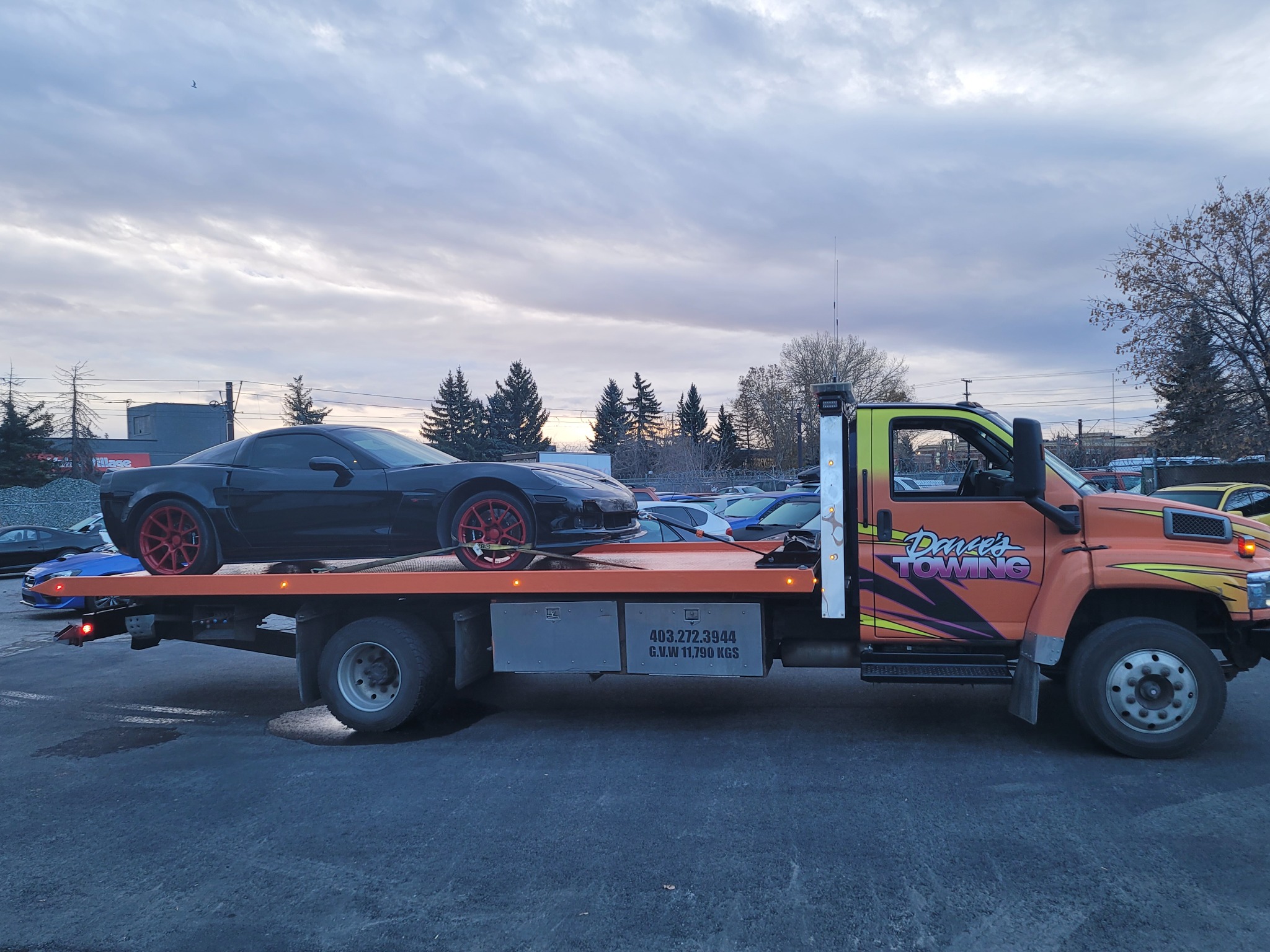 Flatbed towing a classic truck in Okotoks